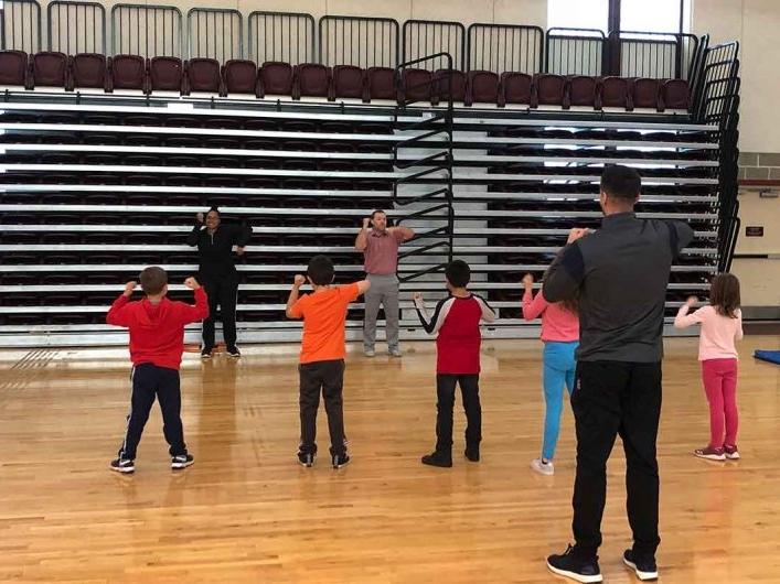 Physical Education students teaching elementary school students in gym 
